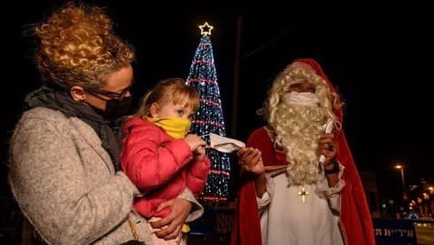 Papá Noel repartiendo desinfectante de manos y máscaras en Jaffa. 