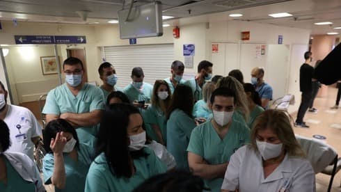 Miembros del personal médico del Centro Médico Ichilov de Tel Aviv forma fila para recibir la vacuna contra el COVID-19. (Moti Kimchi) Miembros del personal médico del hospital Ichilov de Tel Aviv forma fila para recibir la vacuna contra el COVID-19.
