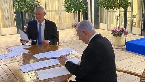 Netanyahu y Gantz firman el acuerdo de coalición en abril.