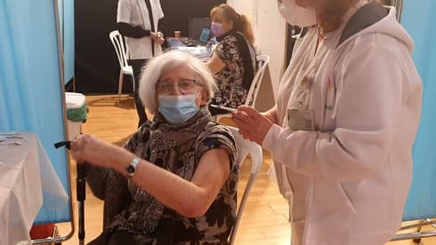 Una mujer recibe la vacuna en Carmiel.