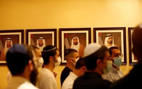 Ciudadanos israelíes con barbijo pasan frente a retratos de jeques en un museo de Dubai. (EPA) Ciudadanos israelíes con barbijo pasan frente a retratos de jeques en un museo de Dubai.