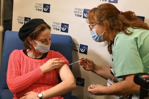 Una maestra israelí recibe la vacuna contra el coronavirus. 