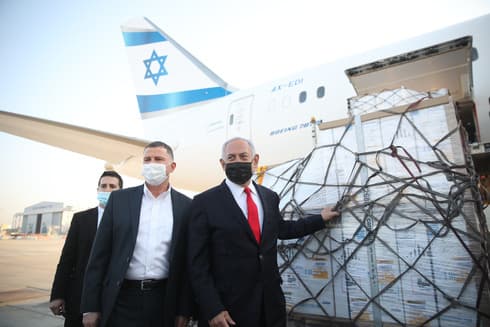 El ministro de Salud Yuli Edelstein y el primer ministro Benjamín Netanyahu reciben el segundo cargamento de vacunas de Pfizer en la pista del Aeropuerto Ben Gurion. 