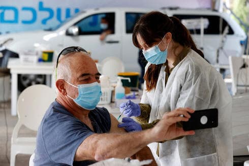 Una de las personas con prioridad para la inoculación recibe su dosis en Haifa. 