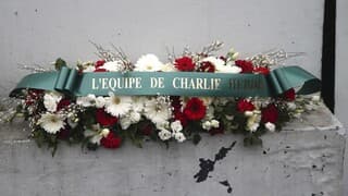 Corona de flores de la revista Charlie Hebdo frente al supermercado "Hyper Cacher" de París. 