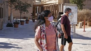 Turistas, con su correspondiente barbijo, recorren las calles de Dubai. 