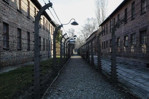 Camino interno que conduce a una torre de observación entre lo que eran cercas de alambre de púa electrificadas en el campo de exterminio de Auschwitz. (AP) Camino interno que conduce a una torre de observación entre lo que eran cercas de alambre de púa electrificadas en el campo de exterminio de Auschwitz.