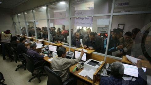 Residentes de Gaza hacen fila para retirar dinero de la ayuda de Catar en Gaza. 
