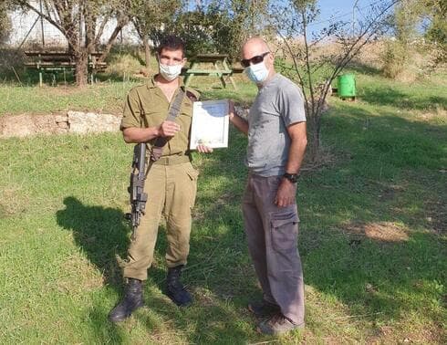 El soldado Ido Gerdi recibe un certificado de buen ciudadano por el hallazgo de la moneda. 