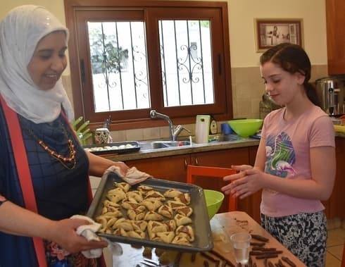 Dos mujeres israelíes, una musulmana y otra judía, hornean hamantashen para la próxima fiesta judía de Purim. 