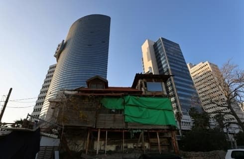 Una antigua casa de madera se encuentra frente a edificios modernos en Tel Aviv. (AFP) Una antigua casa de madera se encuentra frente a edificios modernos en Tel Aviv.