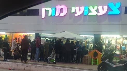 Largas filas en una juguetería para comprar disfraces de Purim. 