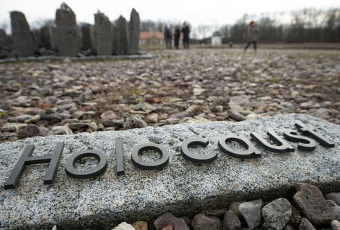 La gente camina detrás de la escritura 'Holocausto' durante el día internacional del recuerdo del Holocausto en el antiguo campo de concentración nazi de Buchenwald. 