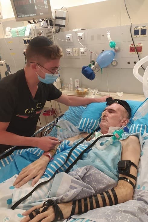 Haim Abush viste los tefilín durante su estadía en el hospital. 