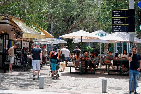Israelíes comen al aire libre después del primer cierre por coronavirus en Israel. 