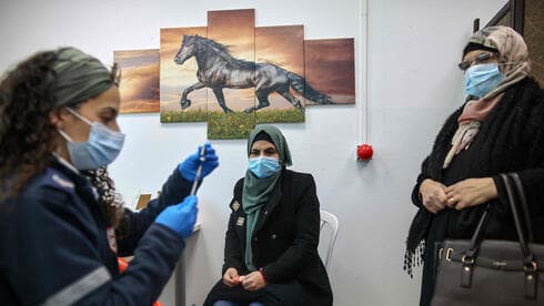 Una mujer palestina recibe su vacuna contra el coronavirus en el puesto de control de Qalandia entre Jerusalem y Cisjordania. (AFP) Una mujer palestina recibe su vacuna contra el coronavirus en el puesto de control de Qalandia entre Jerusalem y Cisjordania.