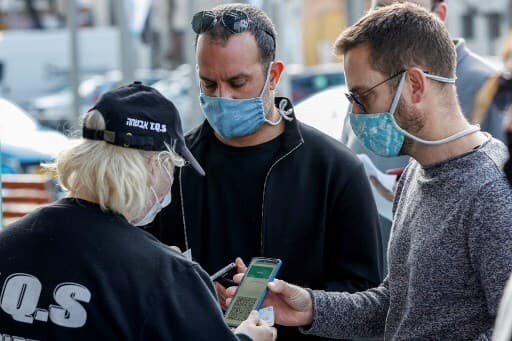 Dos israelíes muestran sus certificados de vacunación para poder ingresar al recital. (AFP) Dos israelíes muestran sus certificados de vacunación para poder ingresar al recital.