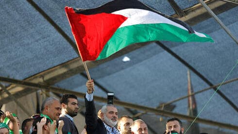 Ismail Haniyeh, máximo líder de Hamás en la Franja de Gaza, ondea una bandera palestina durante un mitin. . 
