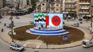 El mural muestra un prisionero tras las rejas en medio del "0", la bandera de la oposición siria y la palabra “Revolución” escrita en árabe. 