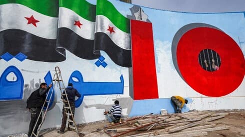 Activistas sirios pintan una pared en recuerdo del levantamiento hace diez años contra el presidente Bashar al-Assad. (AFP) Activistas sirios pintan una pared en recuerdo del levantamiento hace diez años contra el presidente Bashar al-Assad.