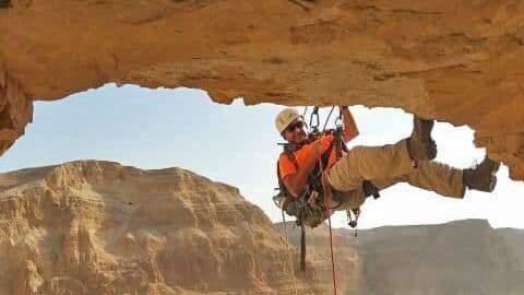 Un arqueólogo desciende en rappel por el acantilado hacia la Cueva del Horror en el desierto de Judea. (Autoridad de Antigüedades de Israel) Un arqueólogo desciende en rappel por el acantilado hacia la Cueva del Horror en el desierto de Judea.