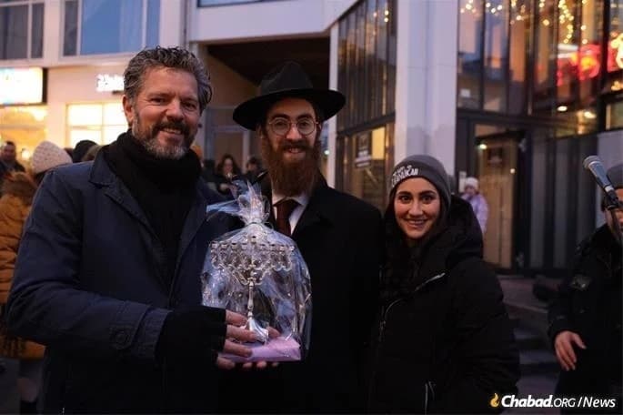 El rabino Avi Feldman y su esposa, Mushky, entregan una menorá al alcalde de Reykjavík, Dagur Bergþóruson Eggertsson. (Chabad.org) Judíos en islandia