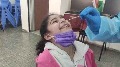 Una joven estudiante es sometida a una prueba de detección de COVID-19. 