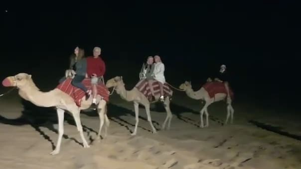 Turistas israelíes disfrutan de un paseo en camello por el desierto de Dubai. 