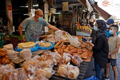 En el Mercado Mehane Yehuda, de Jerusalem, tanto comerciantes como clientes usan mascarillas protectoras al aire libre. (AFP) En el Mercado Mehane Yehuda, de Jerusalem, tanto comerciantes como clientes usan mascarillas protectoras al aire libre.