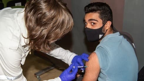 Un joven israelí recibe su segunda dosis de la vacuna contra el COVID-19. (Eyal Amar) Un joven israelí recibe su segunda dosis de la vacuna contra el COVID-19.