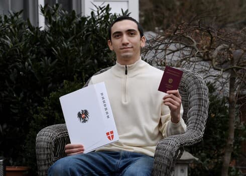 Noah Rohrlich, cuyo abuelo huyó del nazismo en Austria, posa en su casa con su certificado de ciudadanía y un nuevo pasaporte de Austria. (AFP) Noah Rohrlich, cuyo abuelo huyó del nazismo en Austria, posa en su casa con su certificado de ciudadanía y un nuevo pasaporte de Austria.