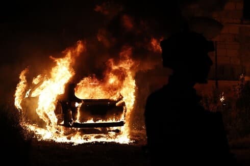 Un automóvil completamente incendiado durante una nueva noche de violencia en el barrio Sheikh Jarrah. (AFP) Incendio Sheikh Jarrah Jerusalem