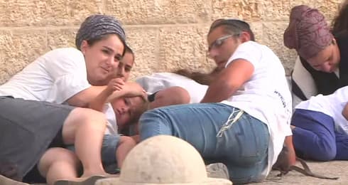 Israelíes se protegen por el disparo de misiles a Jerusalem, el incidente que provocó el inicio de la operación Guardián de los Muros. (AP) No se registraron heridos por la caída de cohetes en el área de Jerusalem.
