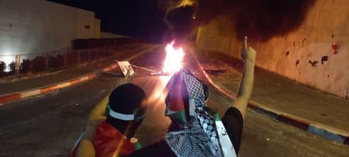 Barricada con neumáticos en llamas en la ciudad de Umm al-Fahm, en el distrito de Haifa. Barricada con neumáticos en llamas en la ciudad de Umm al-Fahm, en el distrito de Haifa.