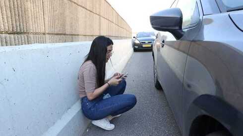 Mujer se refugia en una carretera del norte durante el lanzamiento de cohetes desde el Líbano. (Elad Gershoren) Norte