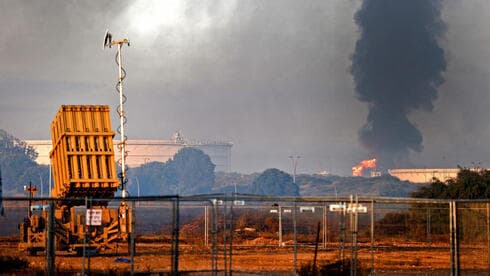 En primer plano, la batería de defensa antimisiles perteneciente a la Cúpula de Hierro. Atrás, fuego en la refinería de Ashkelon. (AFP) En primer plano, la batería de defensa antimisiles perteneciente a la Cúpula de Hierro. Atrás, fuego en la refinería de Ashkelon.