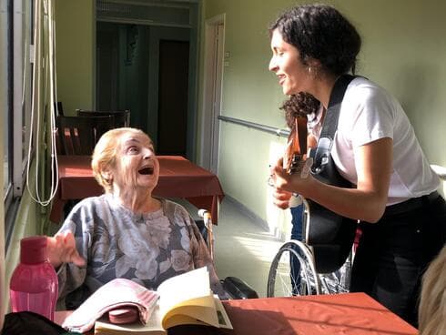 Lucía Abelar canta para una residente de un hogar de ancianos antes de la pandemia. (Cortesía de Lucía Abelar) Lucía Abelar canta para una residente de un hogar de ancianos antes de la pandemia.