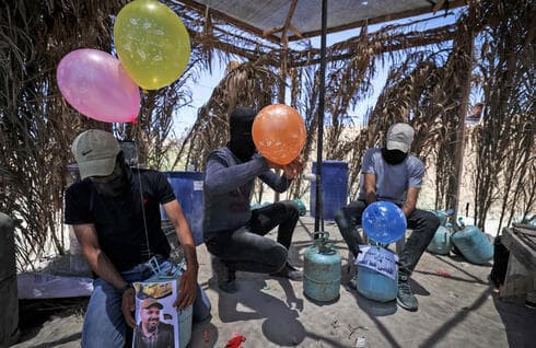 Terroristas de la Yihad Islámica preparan globos explosivos para lanzar a Israel.