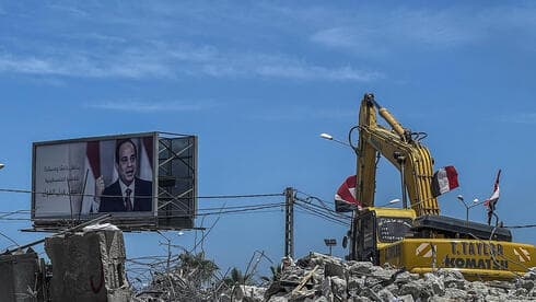 Una excavadora limpia los escombros en Gaza junto a una imagen del presidente egipcio Abdel-Fattah el Sisi, que ha prometido millones de dólares para reconstruir el enclave. (EPA) Una excavadora limpia los escombros en Gaza junto a una imagen del presidente egipcio Abdel Sisi, que ha prometido millones de dólares para reconstruir el enclave.