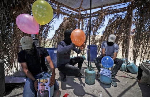 Miembros de la Yihad Islámica preparan globos incendiarios para enviarlos a Israel desde Gaza, el 15 de junio de 2021. (AFP) Miembros de la Yihad Islámica preparan globos incendiarios para enviarlos a Israel desde Gaza, el 15 de junio de 2021.