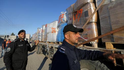 Policías palestinos junto a un camión que traslada ropa para exportación en el cruce Kerem Shalom.