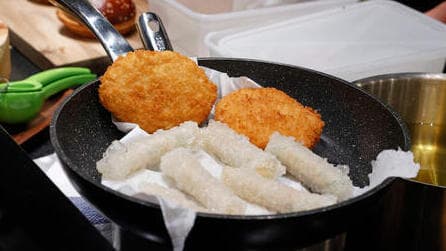 Un chef prepara hamburguesas y rollos de arroz hechos con pollo cultivado. 
