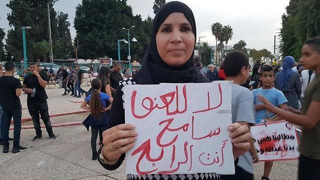Una mujer árabe israelí protesta ante la comisaría de Ramle por la inacción ante la violencia en su comunidad. (Ynet) Una mujer árabe israelí protesta ante la comisaría de Ramle por la inacción ante la violencia en su comunidad.