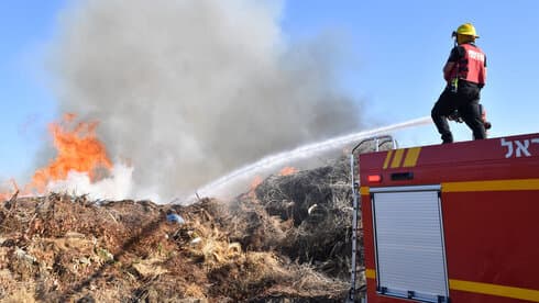 Bomberos extinguen un incendio causado por globos incendiarios lanzados desde Gaza. (Haim Horenstein) Bomberos extinguen un incendio causado por globos incendiarios lanzados desde Gaza.