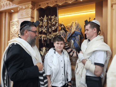 Shaked Winstock celebra su Bar Mitzvá junto a su padre, Edward, y el rabino Menachem Kutner. (Rabino Moshe Grunberg, Organización Juvenil de Jabad para las Víctimas del Terrorismo y la Guerra) Shaked Winstock celebra su Bar Mitzvá junto a su padre, Edward, y el rabino Menachem Kutner.