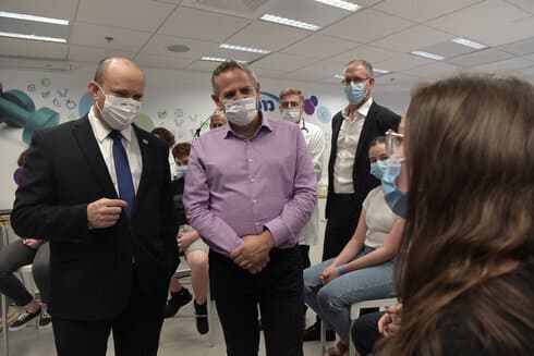 El primer ministro Naftali Bennett y el ministro de Salud, Nitzan Horowitz, visitan un centro de vacunación contra el coronavirus en Holon. (GPO) El primer ministro Naftali Bennett y el ministro de Salud, Nitzan Horowitz, visitan un centro de vacunación contra el coronavirus en Holon.
