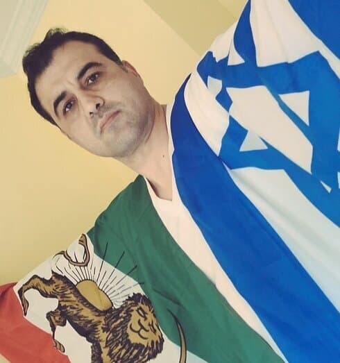 Ahmad Batebi sostiene las banderas iraní e israelí.