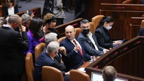 El primer ministro Naftalí Bennett acompañado por miembros de su gobierno en el pleno de la Knesset antes de la votación sobre la Ley de Reunificación Familiar. (Canal de la Knesset) El primer ministro Naftalí Bennett acompañado por miembros de su gobierno en el pleno de la Knesset antes de la votación sobre la Ley de Reunificación Familiar.
