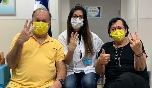 La vacuna aplicada y la seña del número 3, con orgullo por iniciar la campaña. (Maccabi) Vacuna