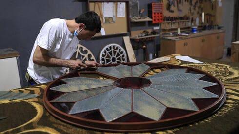 Un carpintero trabaja en la restauración del vidrio de una puerta. 